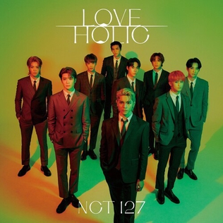 Album cover for NCT 127's "Loveholic", which features all of the 9 NCT 127 members in gray suits. They are standing in a diamond formation with one person in the forefront. The background is an orange-green gradient.